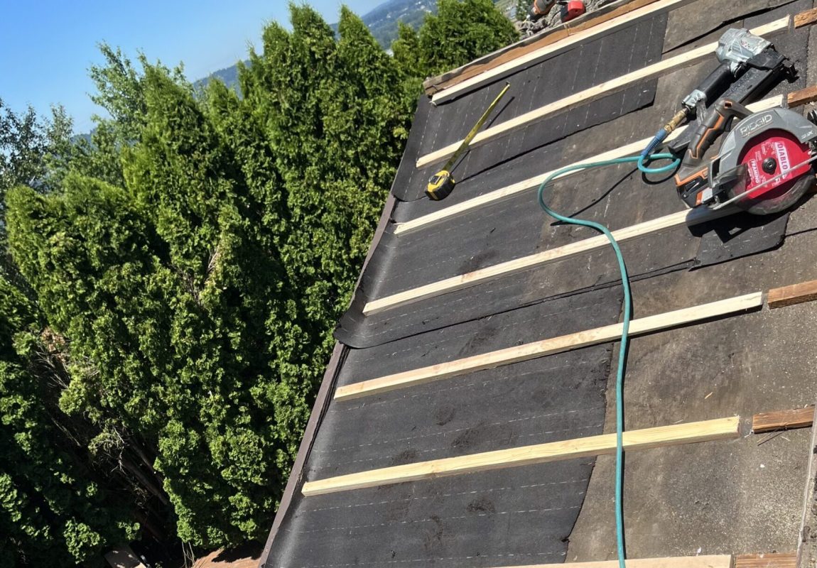 A person is working on the roof of a house.
